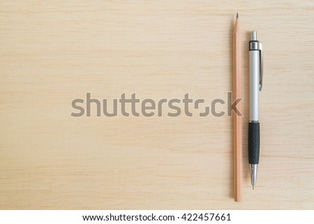 Brown pencil and pen on wooden background