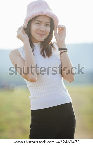 Portrait of beautiful Asian woman on meadow and mountain background. 