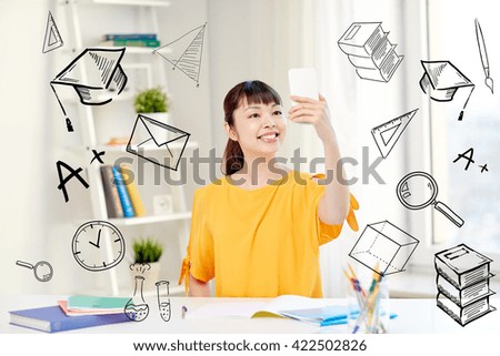people, education, high school and learning concept - happy asian young woman student taking selfie with smartphone at home with doodles