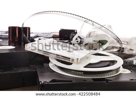 Vintage film camera rolls, old audio and video casettes with tape and foto strip on white background