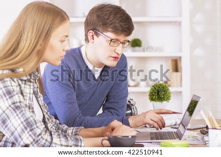 Sideview of two businesspeople working on computer in office