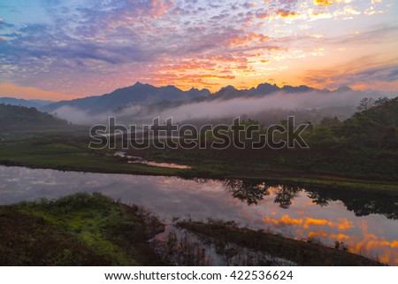 The landscape picture of river, trees, mountains and sea fog from the view point during morning time. 