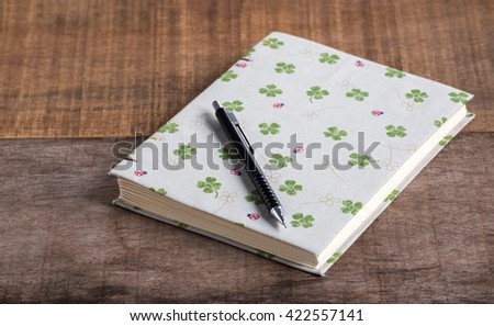 Closeup of handmade book and pen on wooden background