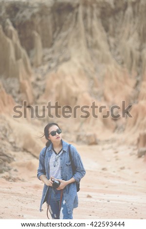Beautiful girl wearing sunglass holds camera.  Vintage color style.