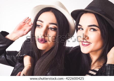 Close up Fashion portrait of two friends,modern lifestyle.Close up fashion portrait of two sisters hugs and having fun together, wearing hats and leather coats best fiend enjoy amazing time together.