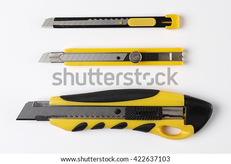 Paper Cutter isolated on White Background. Top View of Yellow Box Cutter Set With Real Shadow. School or Office. Copy Space for Text or Image. Royalty-Free Stock Photo #422637103