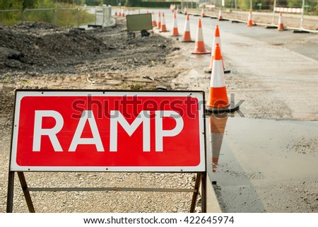 Roadside RAMP Sign with traffic cones and road resurfacing work in the background.