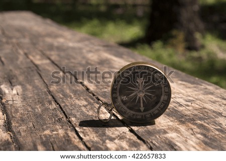 compass on the brown wooden table background/the time-tested Navigator/compass on a wood deck