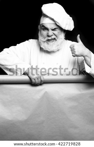 Cook holding parchment paper on grey background, copy space, black and white