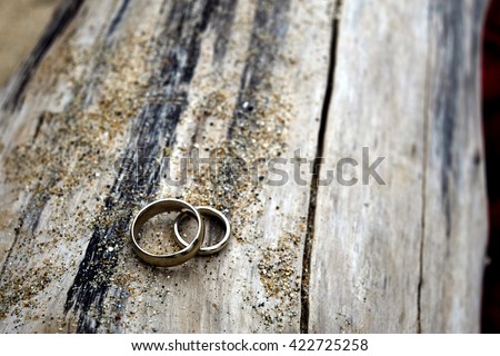 Macro of Pair of Engagement Wedding Rings in Silver White Gold Laying Together on Wood