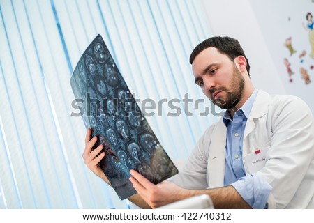 Doctor viewing mri x-ray of brain in office