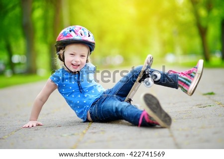 Pretty little girl learning to skateboard outdoors on beautiful summer day