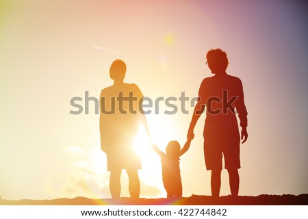 Happy family with child together at sunset
