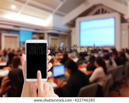 woman use mobile phone and blurred image of people in conference room