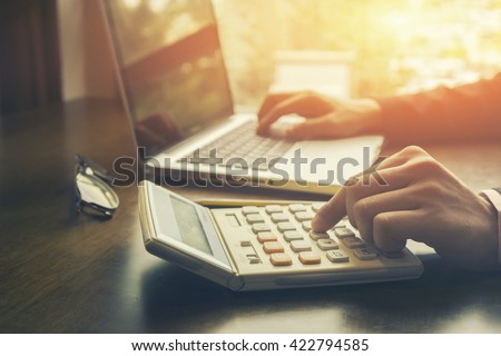 Businessman analyzing investment charts with calculator laptop. Accounting and technology in office.Business people using laptop at office,Analyze plans.selective focus,vintage color
 Royalty-Free Stock Photo #422794585