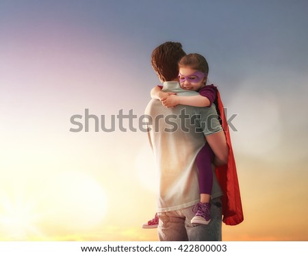 Happy loving family. Father and his daughter child girl playing outdoors. Daddy and his child girl in an Superhero's costumes. Concept of Father's day. Royalty-Free Stock Photo #422800003