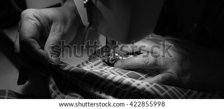 Sewing process with sewing machine. (Selective focus, black and white picture)