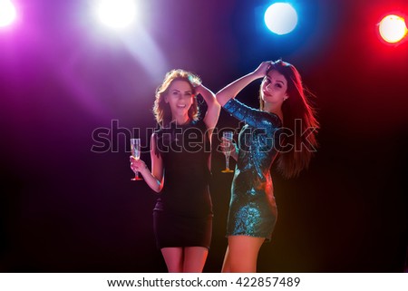 Party, holidays, celebration, nightlife and people concept - smiling young beautiful girls dancing in club
