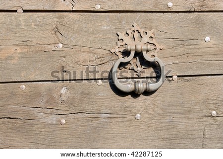 Old door handle on a wooden, knocker