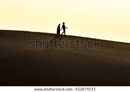 Couple walking together in desert