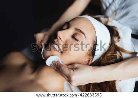 Masseur giving treatment to beautiful brunette Royalty-Free Stock Photo #422883595