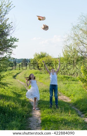 girl and boy throws up their hat