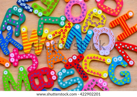 Random Abstract Pattern From English Wooden Colorful Letters On the Brown Wood Background