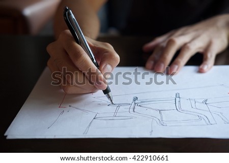 The hand of the designer with a pen, designing and sketching a furniture product