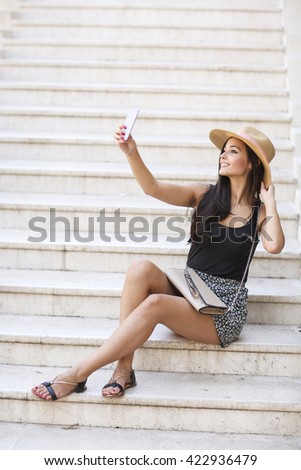 Woman on the stairs outside taking selfie