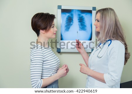 doctor explaining diagnosis to her female patient analysing x-ray photography.