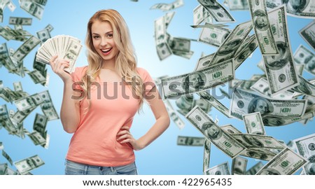 money, finances, investment, saving and people concept - happy young woman with dollar cash over money rain and blue background
