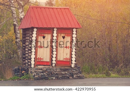 Timbered public toilet with a red roof