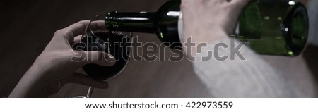 Picture of a woman pouring herself a full glass of wine, panorama