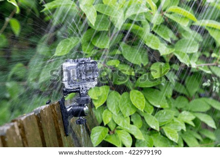 Action camera under heavy rain on nature background