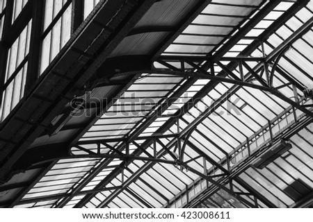 Architectural detail of transparent metal roof of Lyon railway station in Paris (France). Black and white photo.