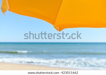 Holiday view of sun umbrella, sandy beach and ocean shore background outdoors