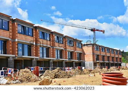 Crane and construction of new buildings. Beautiful background for the construction industry at sunset. Royalty-Free Stock Photo #423062023