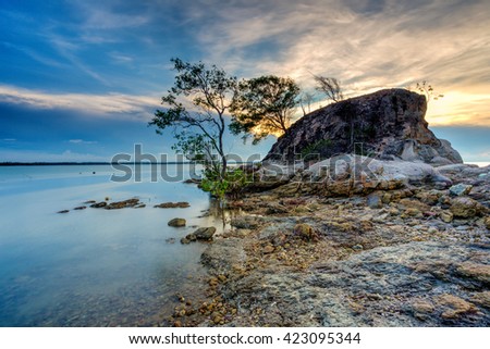 A Long Exposure Picture Of Beautiful Scenery Sunset With Big Stone As Background