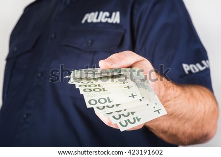 In the picture a corrupt policeman taking bribe