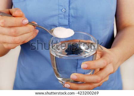 Girl dilutes the baking soda in a glass of water
