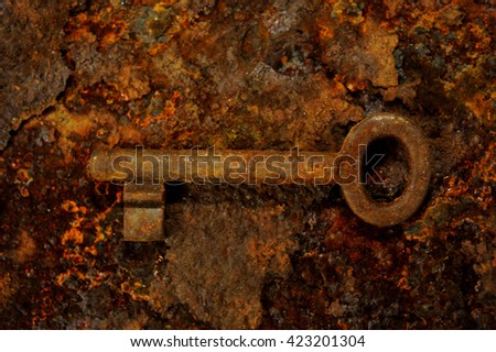 Close up of rusty vintage key lying on old iron plate