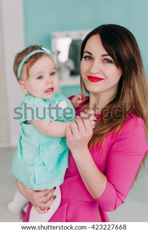 Mother and baby closeup portrait, happy faces, european family picture, adorable small girl, mom and kid having fun indoor, parents joy, holding little child, mommy, happiness concept
