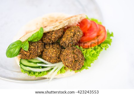 Falafel in pita bread and vegetables - Oriental cuisine. Tasty street food . Excellent choice for lunch and dinner. Close-up on a white background .
 Royalty-Free Stock Photo #423243553