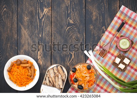 Light snacks on a dark background of old wood. Checkered cloth and thread. Korean cuisine.