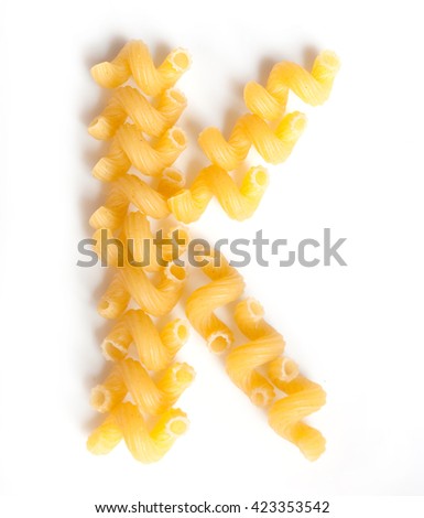 Letter K made of macaroni under a daylight isolated on white background