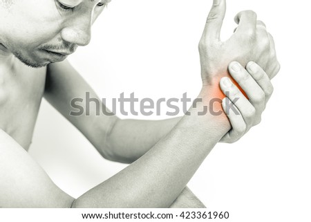 Young man holding his wrist in pain, isolated on white background, monochrome photo