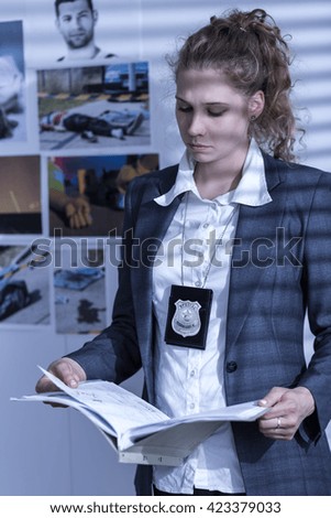 Shot of a young detective reading case files