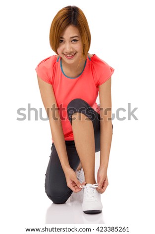 Asian young woman tying running shoes laces Isolated on white.