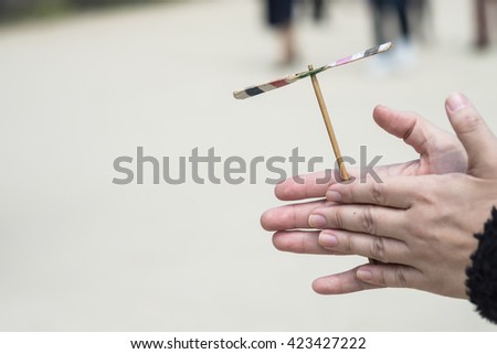 Bamboo copter or wooden copter in hands, a traditional Japanese flying toy made from bamboo. Royalty-Free Stock Photo #423427222