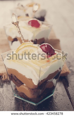 orange dessert  with cream in glass on dark . toned photo